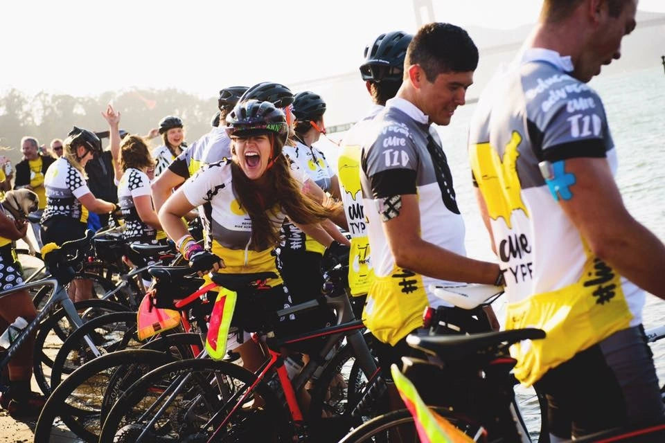 Sierra and her bike teammates dipping their front tires in the Pacific Ocean right next to the Golden Gate Bridge after cycling from New York City, 10 weeks after dipping their rear tires in the Atlantic Ocean.